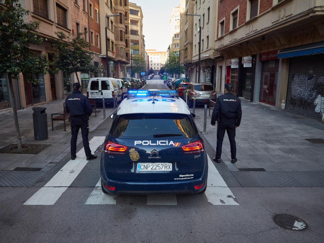 Dos agentes de la Policía Nacional junto a su coche