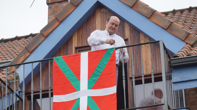 El presidente del EBB del PNV, Andoni Ortuzar, cuelga la ikurriña en el balcón de su casa con motivo del Aberri Eguna