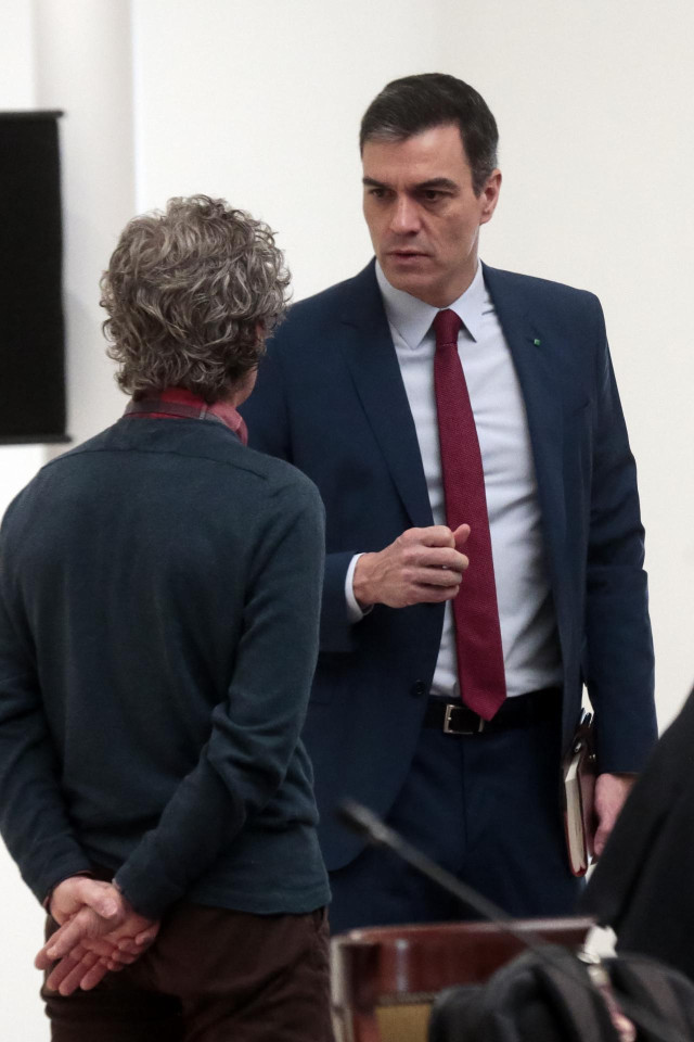 El presidente del Gobierno, Pedro Sánchez, conversa con el director del Centro de Coordinación de Alertas y Emergencias Sanitarias del Ministerio, Fernando Simón (de espaldas), antes de la reunión del Comité Técnico de Gestión, a 14 de abril de 2020.