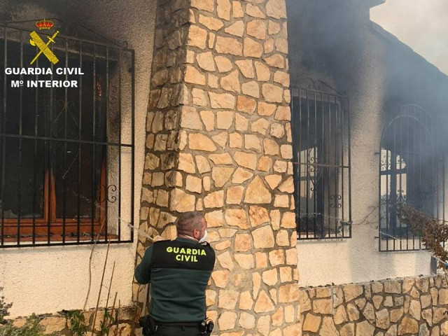 Uno de los agentes con la manguera intenta sofocar las llamas.