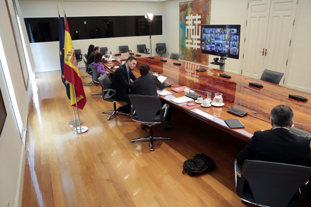El ministro del Interior, Fernando Grande Marlaska (1d); el ministro de Sanidad, Salvador Illa (2d); y la ministra de Defensa, Margarita Robles (3i); asisten a la reunión por videoconferencia del presidente del Gobierno, Pedro Sánchez (3d), con los presid