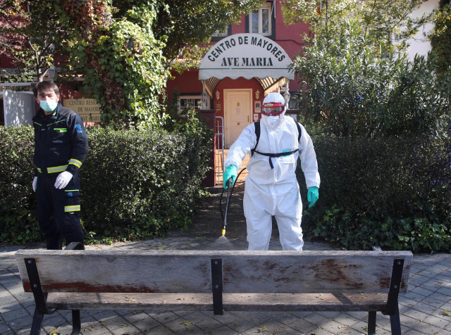 Un bombero del Ayuntamiento de Madrid desinfecta las zonas exteriores de la Residencia de Mayores Ave María