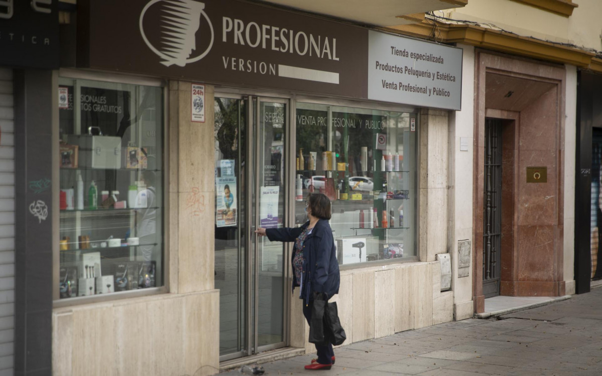 Una mujer en la puerta de una tienda de artículos de peluquería. Según el plan de desescalada del Gobierno central, las peluquerías podrán abrir el próximo lunes 4 de mayo. En Sevilla, (Andalucía, España) a 30 de abril de 2020.
