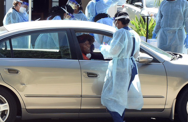 April 21, 2020 - Altamonte Springs, Florida, United States -A health worker tests a man for COVID-19 at a mobile testing site at the Apostolic Church of Christ in a historic black neighborhood on April 21, 2020 in Altamonte Springs, Florida. State and cou