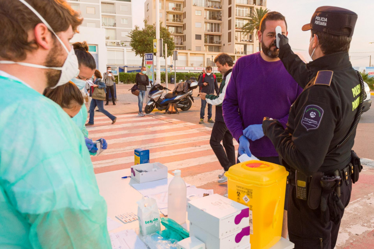 Un agente de la Policía Portuaria mide la temperatura a un visitante en Formentera.