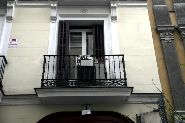 Cartel colgado en un edificio que indica que el inmueble está en venta.
