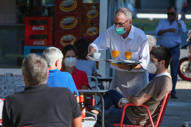 Un camarero sirve a los clientes en una terraza de un bar después de que el Ministerio de Sanidad autorizara a que la totalidad de la Comunidad Valenciana pasase en su conjunto a la fase 1 de la desescalada.