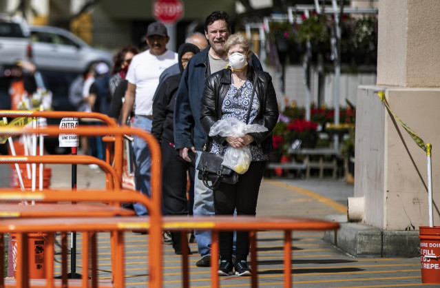 Consumidores hacen cola para entrar en una tienda de The Home Depot