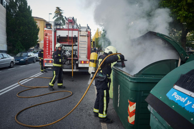 Una dotación de bomberos apaga un contenedor de basura que los manifestantes han prendido en señal de protesta durante la manifestación celebrada en Pamplona en apoyo al preso etarra Patxi Ruiz