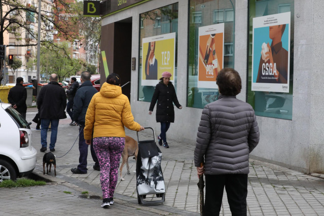 Personas en fila guardan su turno para entrar en una oficina de Bankia dos días antes de que la entidad bancaria inicie el abono de las prestaciones por desempleo del Servicio Público de Empleo Estatal (SEPE), que el banco ha adelantado con el objetivo de