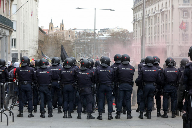 Agentes de la Policía Nacional frente a los manifestantes concentrados en el Congreso de los Diputados en rechazo a la no autorización por el Gobierno a la tramitación parlamentaria de la Iniciativa Legislativa Popular (ILP) presentada por Jusapol