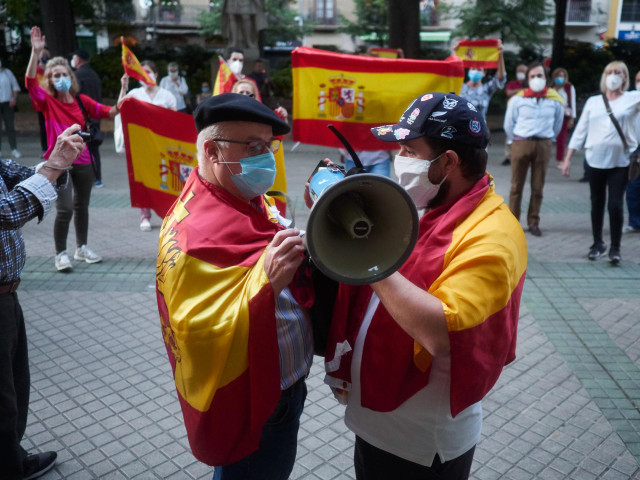 Varias personas con banderas de España protestan en la puerta de la sede del PSOE del Paseo Sarasate de Pamplona por la gestión del Gobierno en la pandemia de coronavirus COVID19, en Pamplona, Navarra, España, a 21 de mayo de 2020.