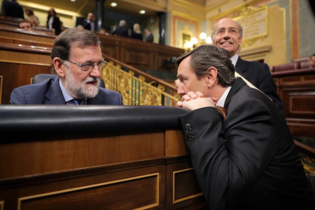 El que fuera presidente del Gobierno, Mariano Rajoy, conversa en el  escaño con Rafael Hernando, entonces portavoz del Grupo Popular en el Congreso.