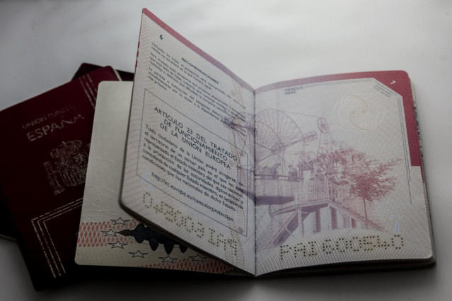 Un pasaporte abierto sobre una mesa.