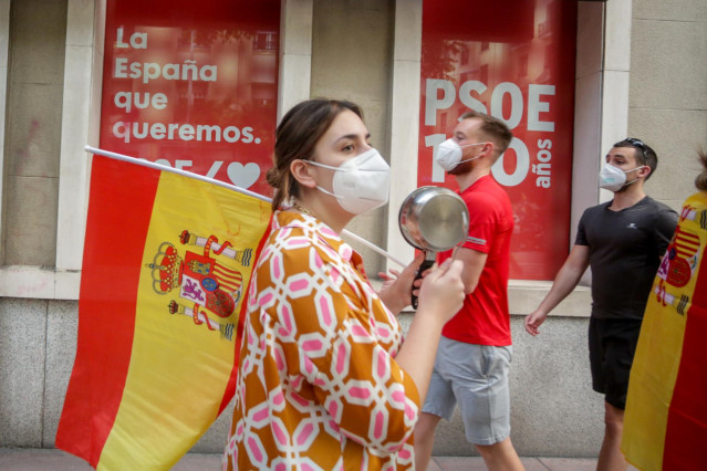Una mujer toca una cacerola durante el cuarto día de protestas por la gestión del Gobierno en la crisis del coronavirus, frente a la sede del PSOE de la calle Ferraz en Madrid a 19 de mayo de 2020.