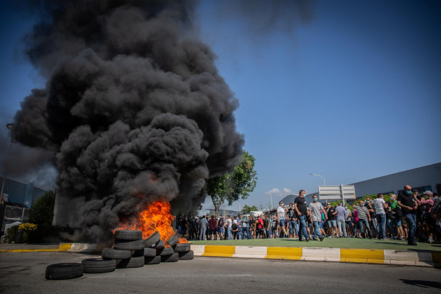 Trabajadores de la planta de producción de Nissan en Barcelona queman neumáticos en el exterior de la fábrica en la Zona Franca