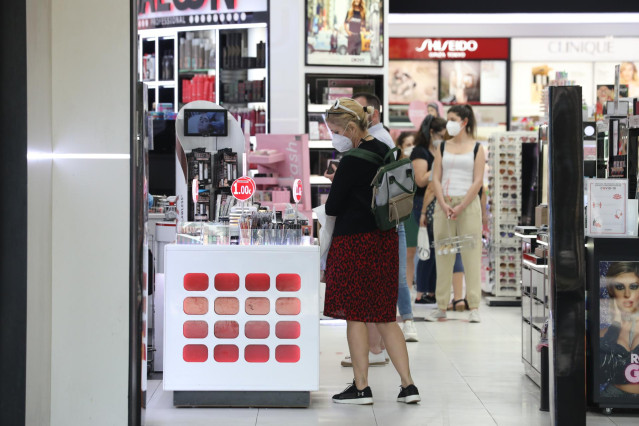 Varias personas con mascarilla en una perfumería abierta en el primer día de la fase 1 en Madrid.