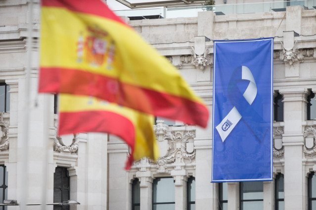 Bandera en la Fuente de Cibeles y bandera con el lazo que simboliza la lucha unida del pueblo de Madrid en la fachada del Ayuntamiento