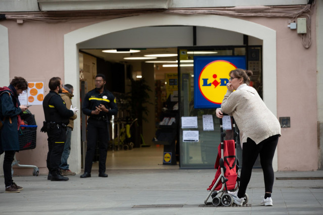 Una mujer espera con su carro de la compra a poder entrar a un supermercado Lidl tras las medidas de aforo impuestas por seguridad, durante el segundo día laborable del estado de alarma por el coronavirus, en Barcelona/Catalunya (España).