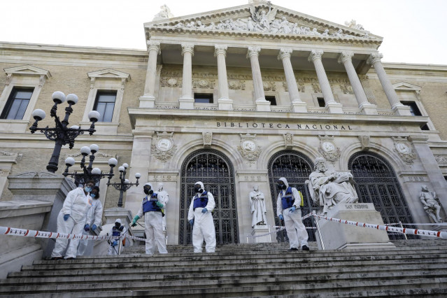Agentes de la UME con mochilas nebulizadoras en la desinfección de las escaleras de la entrada de la Biblioteca Nacional