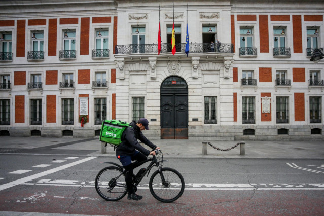 Un 'rider' de Uber Eats circula por la Puerta del Sol, en Madrid (España) a 19 de abril de 2020.