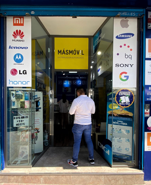 Un hombre espera frente a un distribuidor autorizado de la compañía de telecomunicaciones MásMóvil en Madrid