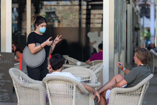 Varias personas piden consumiciones en una terraza en el Mercado de Colón durante la fase 2 de la desescalada en la pandemia de coronavirus COVID19.