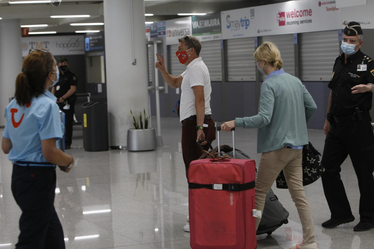 Dos viajeros procedentes de Alemania llegan al Aeropuerto de Palma de Mallorca el día en el que arranca en Baleares el plan piloto