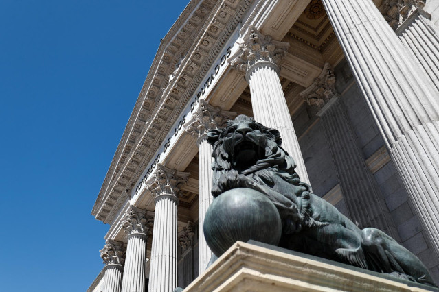 Uno de los emblemáticos leones que se encuentran delante de la fachada del Congreso de los Diputados en la Plaza de las Cortes de Madrid.