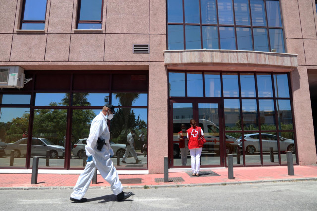 Agentes de la Policía Nacional equipados con Equipos de Protección Individual (EPI), custodian usuarios afectados por COVID-19