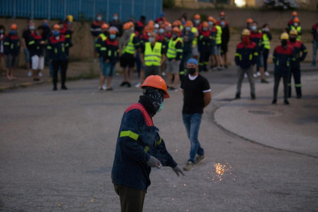 Un manifestante tira un petardo durante una concentración nocturna convocada por el comité de Alcoa San Cibrao, en el entorno de la fábrica de San Cibrao, en Lugo, Galicia (España), a 30 de junio.