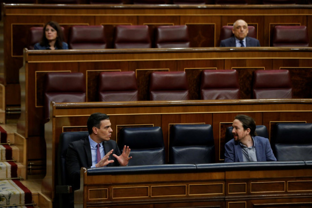 El presidente del Gobierno, Pedro Sánchez (i), conversa con el vicepresidente segundo, Pablo Iglesias, en el Congreso