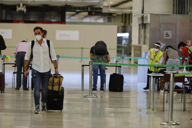 Pasajeros procedentes de Londres rellenan un formulario a su llegada al Aeropuerto de Madrid-Barajas Adolfo Suárez.