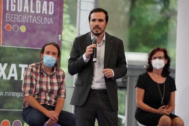 El coordinador general de IU y Ministro de Consumo, Alberto Garzón (c), durante su intervención junto al secretario general de Podemos y vicepresidente segundo del Gobierno y Ministro de Derechos Sociales y para la Agenda 2030, Pablo Iglesias