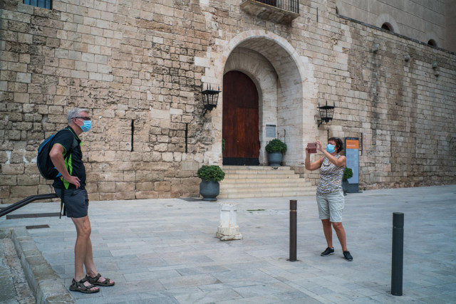Dos turistas hacen una foto junto a la Almudaina