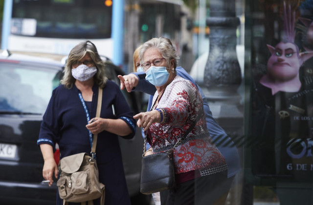 Transeúntes pasean por calles de Santander con mascarilla