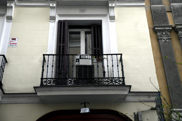 Cartel colgado en un edificio que indica que el inmueble está en venta.