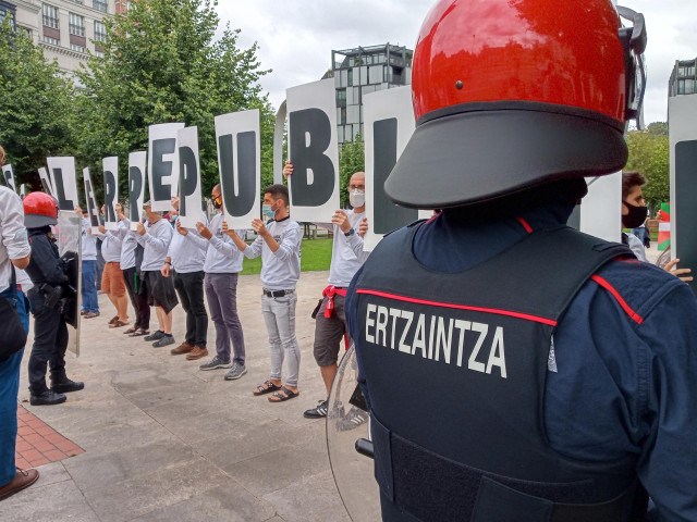 Agentes de la Ertzaintza vigilan en Bilbao el desarrollo de la concentración convocada por Sortu para protestar por la visita de los Reyes a Euskadi.
