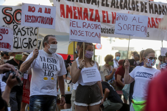 Comerciantes de El Rastro madrileño sostienen pancartas durante la manifestación en la Plaza del Cascorro para exigir sus puestos habituales y recuperar el modelo 