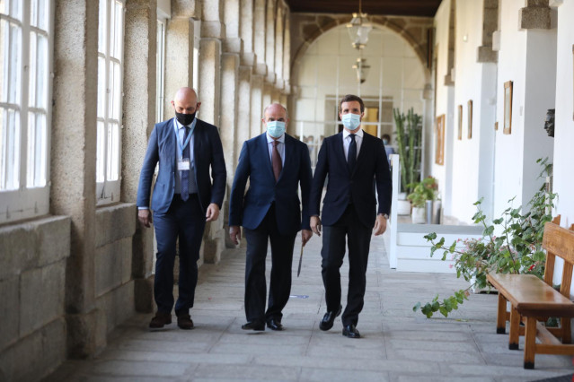 El vicepresidente del Banco Central Europeo y exministro de Economía, Luis de Guindos (c), y el presidente del PP, Pablo Casado (d) antes de participar en la conferencia 'La respuesta europea frente a la crisis'