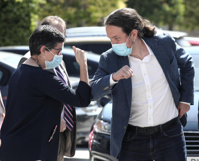 La ministra de Asuntos Exteriores y Cooperación, Arancha González Laya, saluda con el codo al vicepresidente segundo del Gobierno, ministro de Derechos Sociales y Agenda 2030, Pablo Iglesias,  antes de intervenir ambos en la ponencia ‘La centralidad del o