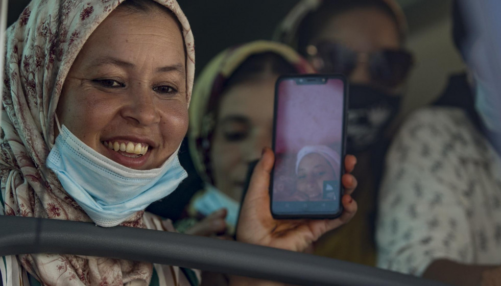 Una de las temporeras en el autobús, hace una videollamada mientras espera para entrar al Muelle Sur del Puerto de Huelva para embarcar rumbo a Marruecos.