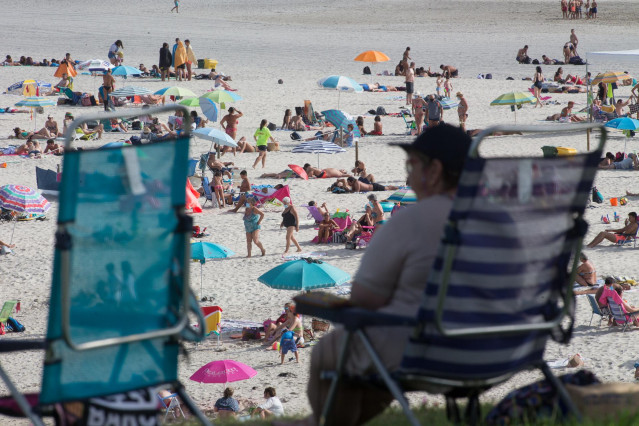 Una persona sentada frente a la playa en A Mariña (Lugo/Galicia) a 27 de julio de 2020.