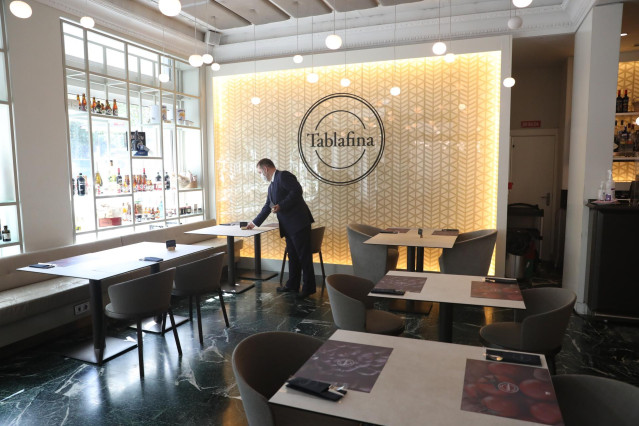 Un camarero prepara una mesa en el restaurante Tablafina en el Paseo del Prado durante la segunda fase de la nueva normalidad en la que el aforo permitido en las zonas comunes de los restaurantes aumenta hasta el 75%.