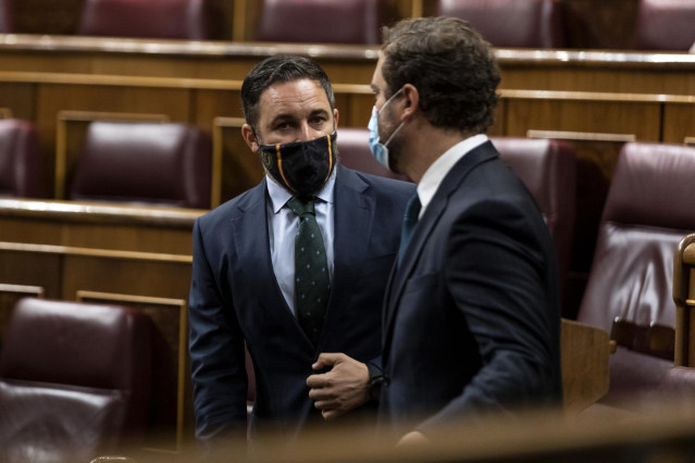 El presidente y el portavoz de Vox, Santiago Abascal e Iván Espinosa de los Monteros, charlan antes del inicio de una sesión plenaria.