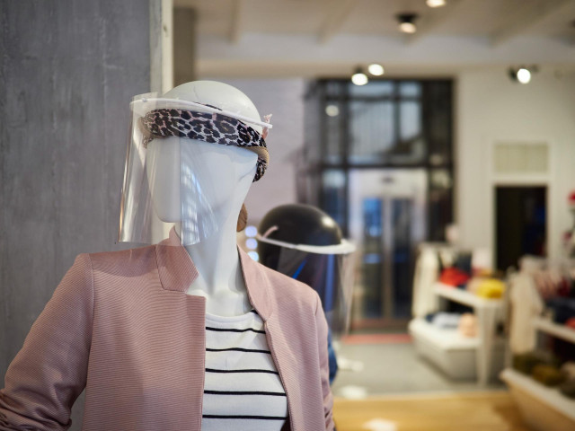 Detalle de unos maniquíes con máscaras de protección en las tiendas de moda 
