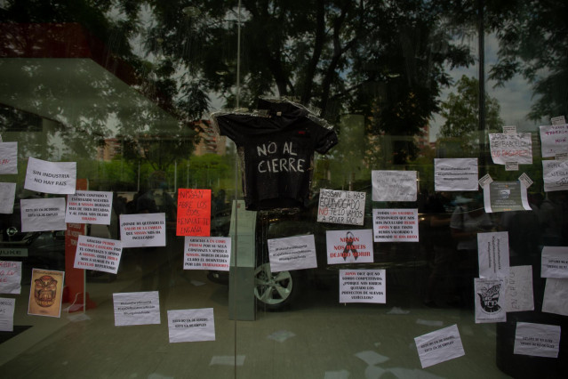Trabajadores de Nissan cuelgan carteles como signo de protesta en el corte que han realizado en la Gran Vía de L’Hospital (Barcelona), cerca del concesionario de Nissan Motor Llansà.