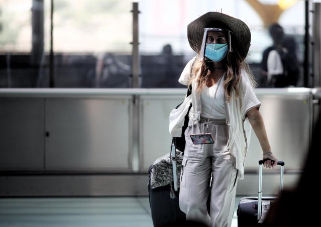 Una pasajera caminando con maleta por un pasillo de la terminar T4 del Aeropuerto Adolfo Suárez Madrid Barajas, en Madrid (España), a 24 de julio de 2020.