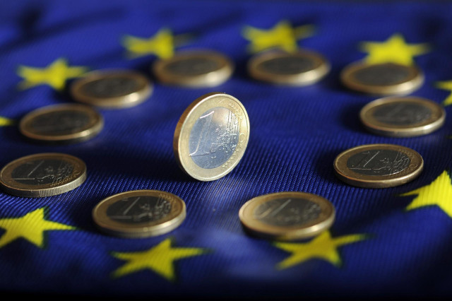 Monedas de euro sobre la bandera de la UE