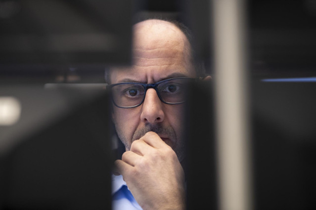 12 March 2020, Hessen, Frankfurt_Main: A stock trader looks at monitors in the trading room of the Frankfurt Stock Exchange.